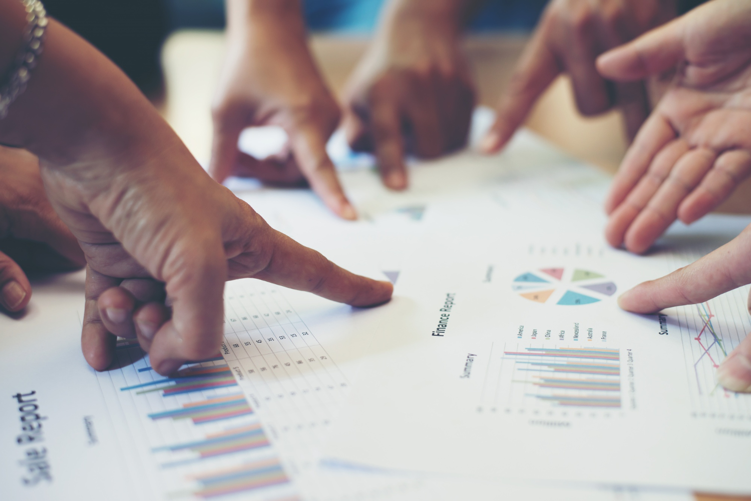 hands point to chart paper on the table